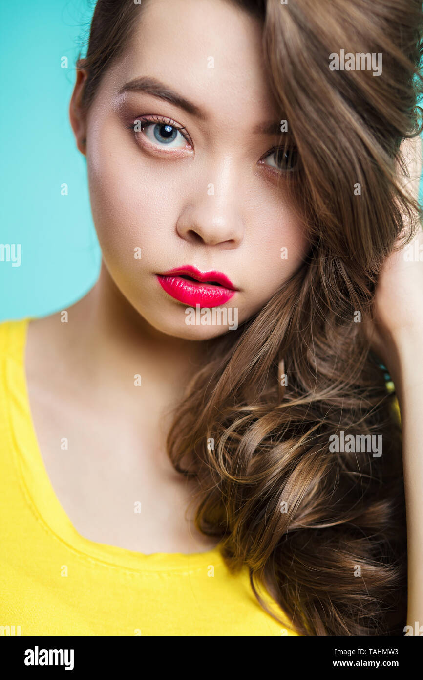 Portrait of beautiful woman against blue background. Stock Photo