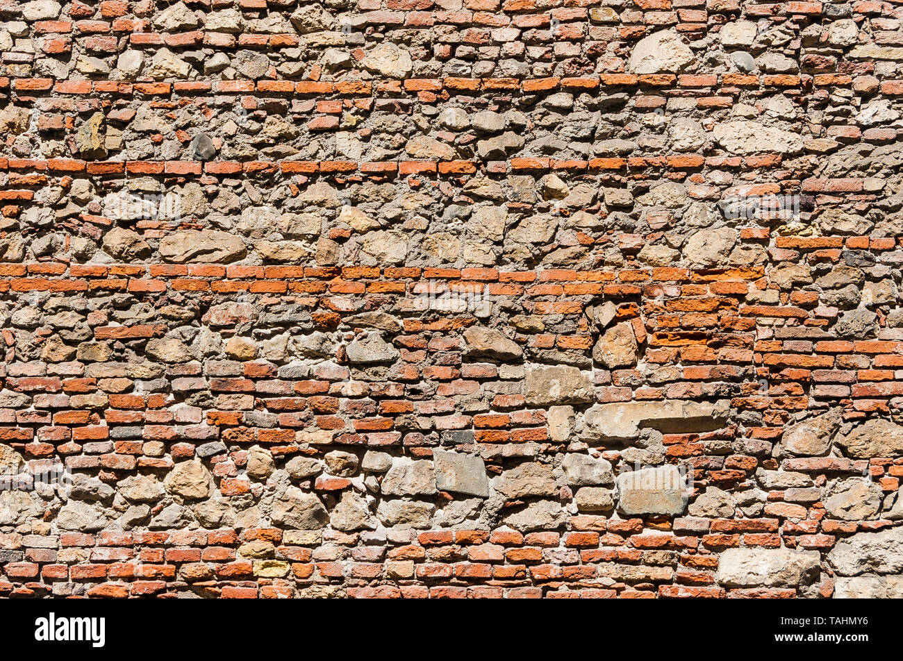 Composite old stone and bricks wall with rough surface as background Stock Photo