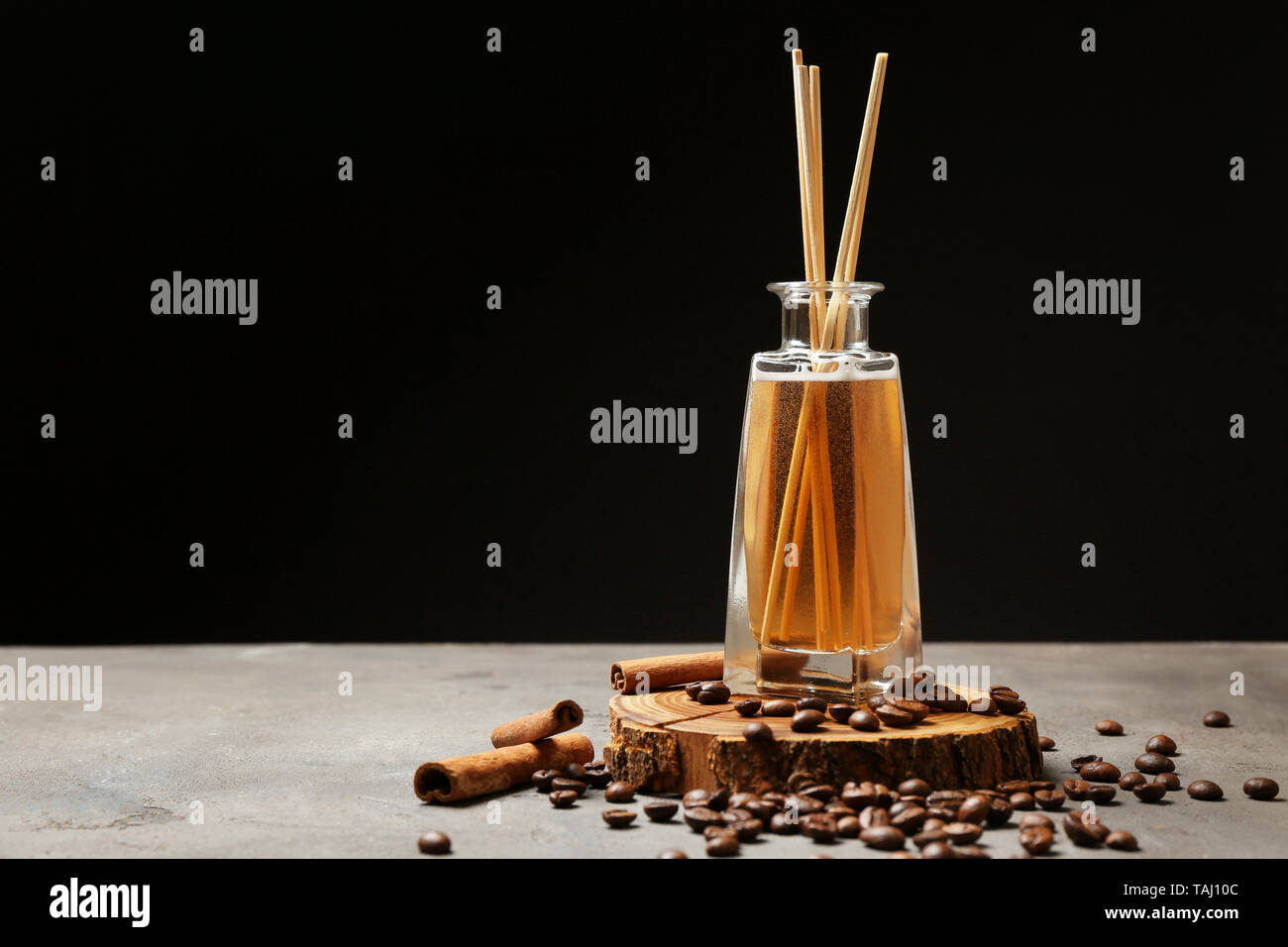 Reed diffuser, coffee beans and cinnamon on table Stock Photo