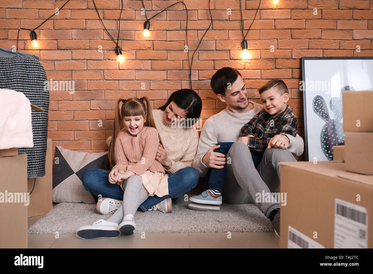 Family with cardboard boxes after moving into new house Stock Photo Alamy