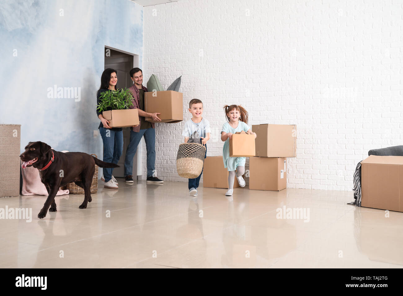 Family with cardboard boxes after moving into new house Stock Photo Alamy