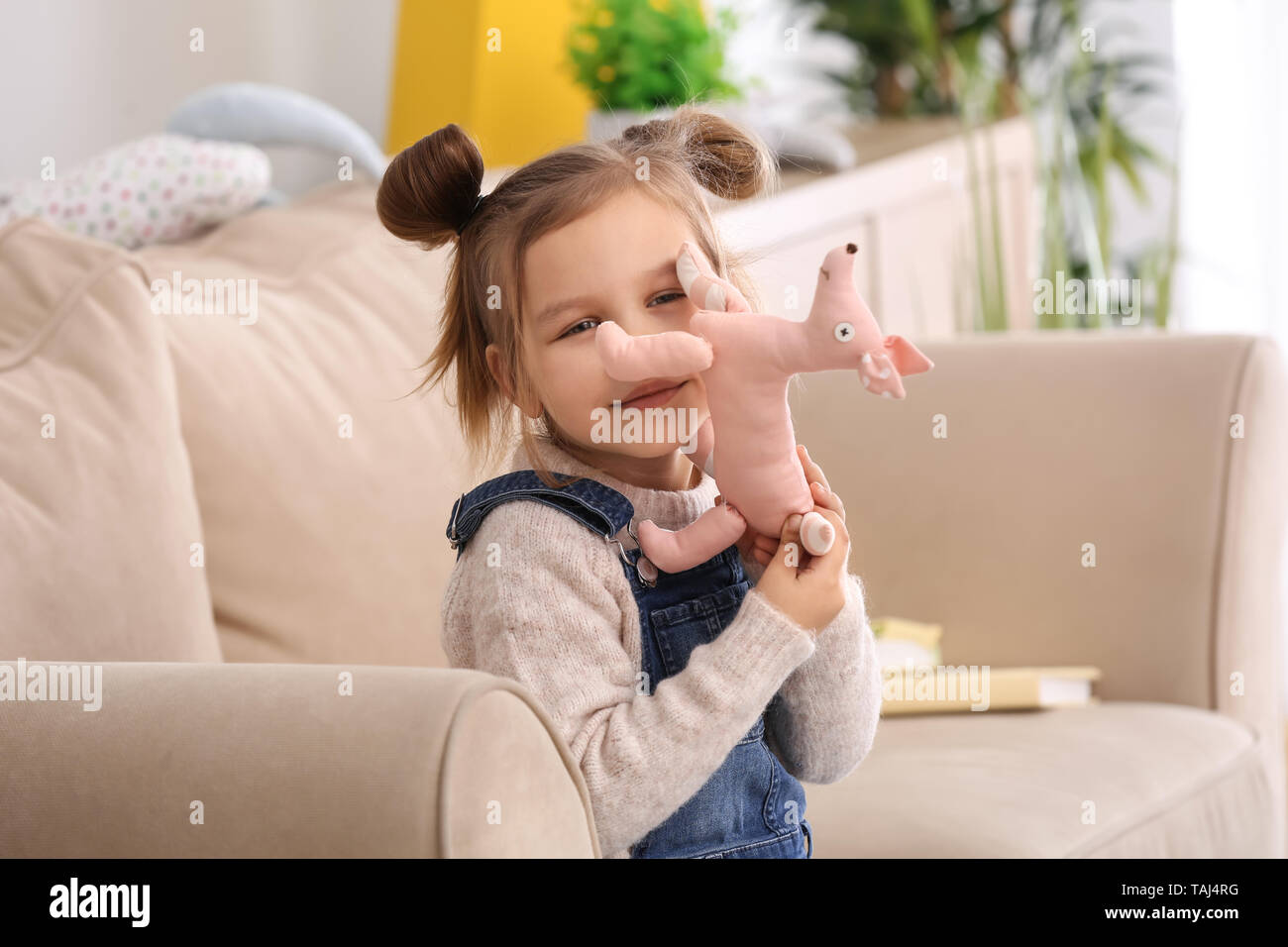 Portrait of cute little girl with toy at home Stock Photo - Alamy