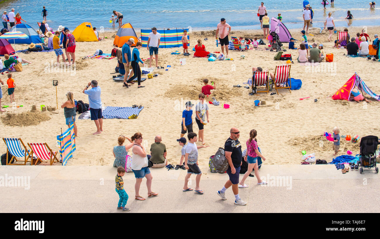 Lyme Regis, Dorset, UK. 25th May 2019. UK Weather: Crowds of holidaymakers and visitors flock to the beach at Lyme Regis to  bask in hot sunshine as the coastal resort sizzles on the hottest day of the year so far. Saturday is set to be the sunniest day of the late May bank holiday weekend.  Credit: Celia McMahon/Alamy Live News. Stock Photo