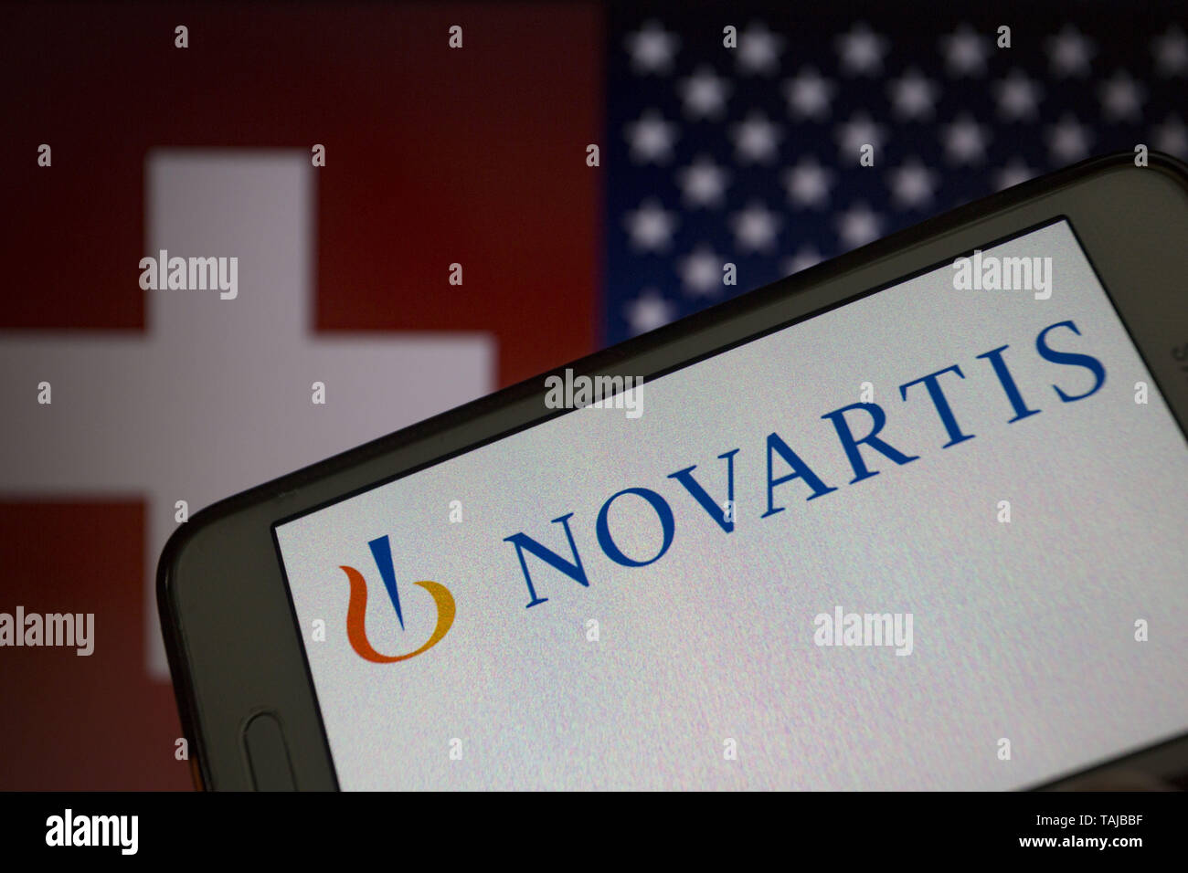 Asuncion, Paraguay. 25th May, 2019. Logo of Novartis, a Swiss multinational  pharmaceutical company, is seen on a smartphone screen against Switzerland  and United States flags unfocused on background. Credit: Andre M. Chang/ZUMA