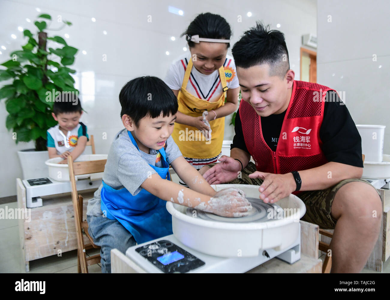 Cixi, China's Zhejiang Province. 25th May, 2019. Pupils make pottery wares under the instruction of a volunteer in Cixi City, east China's Zhejiang Province, May 25, 2019. A volunteer center in Cixi City opened a pottery class for local pupils in celebration of the upcoming International Children's Day. Credit: Xu Yu/Xinhua/Alamy Live News Stock Photo