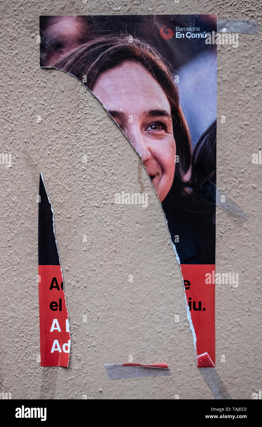 An electoral propaganda poster of the current mayor Ada Colau is seen half-torn. Election posters are seen broken, manipulated or covered by other posters during the last week of the election campaign. Stock Photo