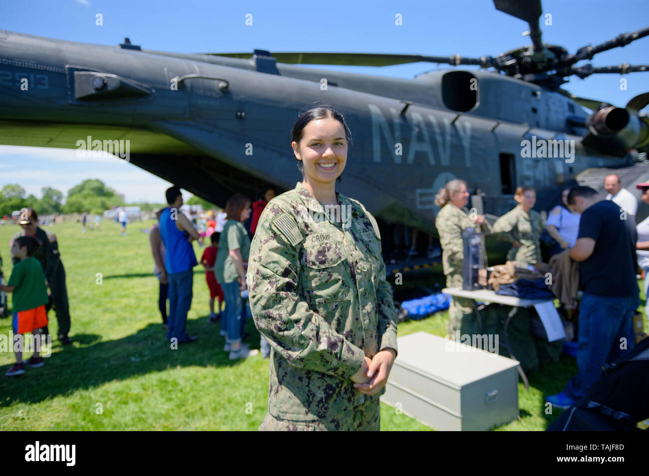 May 25, 2019 - East Meadow, New York, United States - Aviation Electricians Mate Airman (AE) CRUMP poses in front of a U.S. Navy MH53-E helicopter at the Navy hosted aviation event, as part of Fleet Week, on Memorial Day Weekend at Eisenhower Park on Long Island. Helicopter Mine Countermeasures Squadron 14 has a Korea deployment mine sweeping.  It's the largest helicopter in the Navy, and also carries heavy loads and transports and picks up things for the Navy. (Credit Image: © Ann Parry/ZUMA Wire) Stock Photo