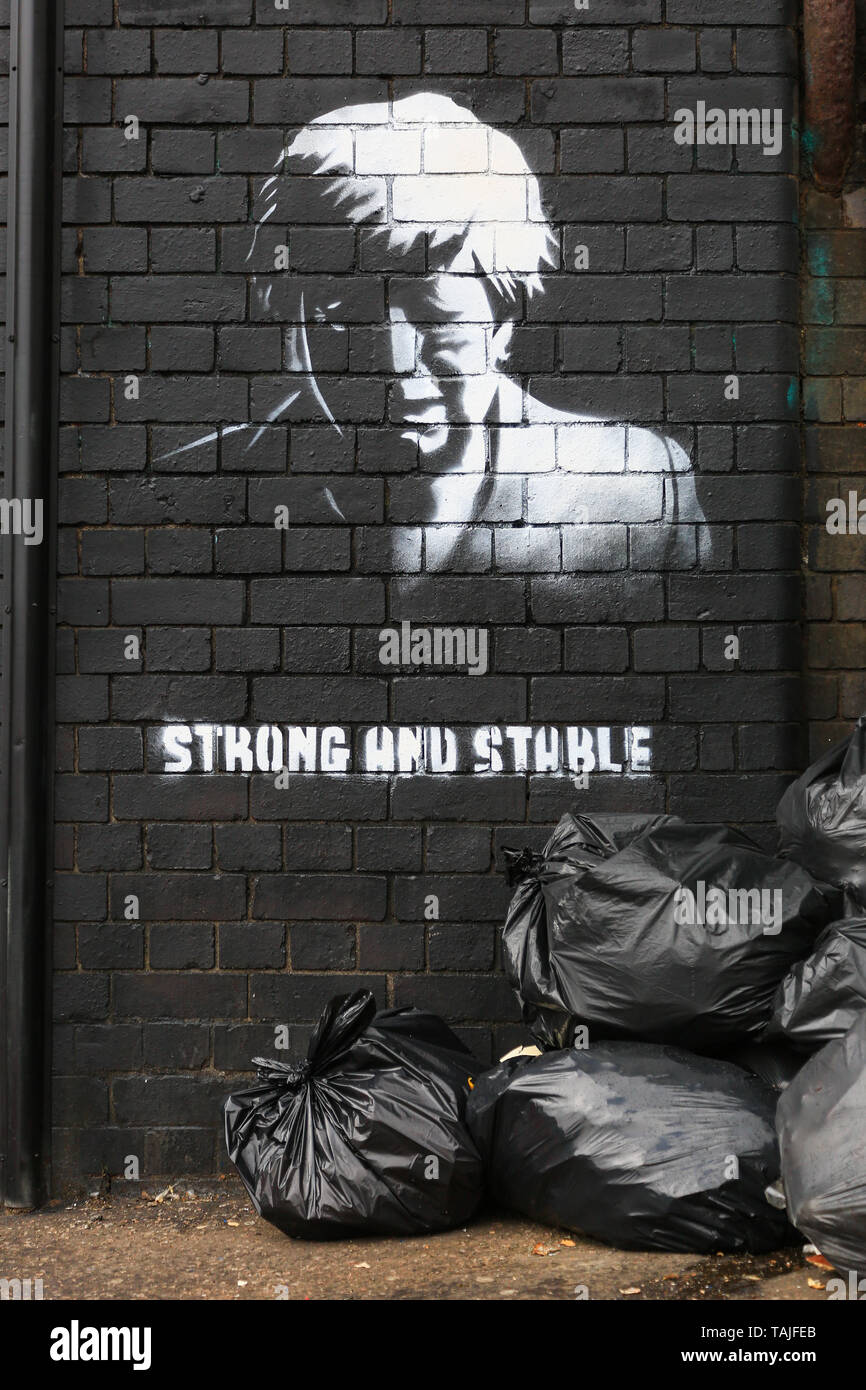 Birmingham, UK. 26th May, 2019. A piece of graffiti art has appeared overnight on a street corner in Birmingham apparently mocking the UK Prime Minister's emotional resignation speech as well as the Conservative Party's 2017 slogan 'strong and stable'. The graffiti has been sprayed skilfully on a brick wall in Digbeth - a run-down area of Birmingham city. The work appears like a Banksy-style political statement, and rumours on Facebook purport it it be by a local artist Mohammed Ali Aerosol though this cannot be confirmed. Credit: Peter Lopeman/Alamy Live News Stock Photo