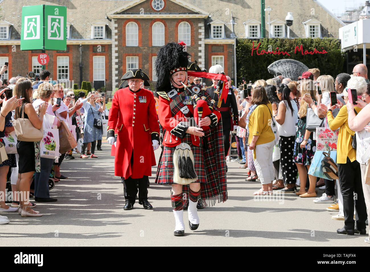 London, UK. 25th May 2019. A Scottish bagpiper leads a Chelsea Pensioners march at the RHS Chelsea Flower Show on the final day of the show. The Royal Horticultural Society Chelsea Flower Show is an annual garden show held in the grounds of the Royal Hospital Chelsea in West London since 1913.  Credit: Dinendra Haria/Alamy Live News Stock Photo