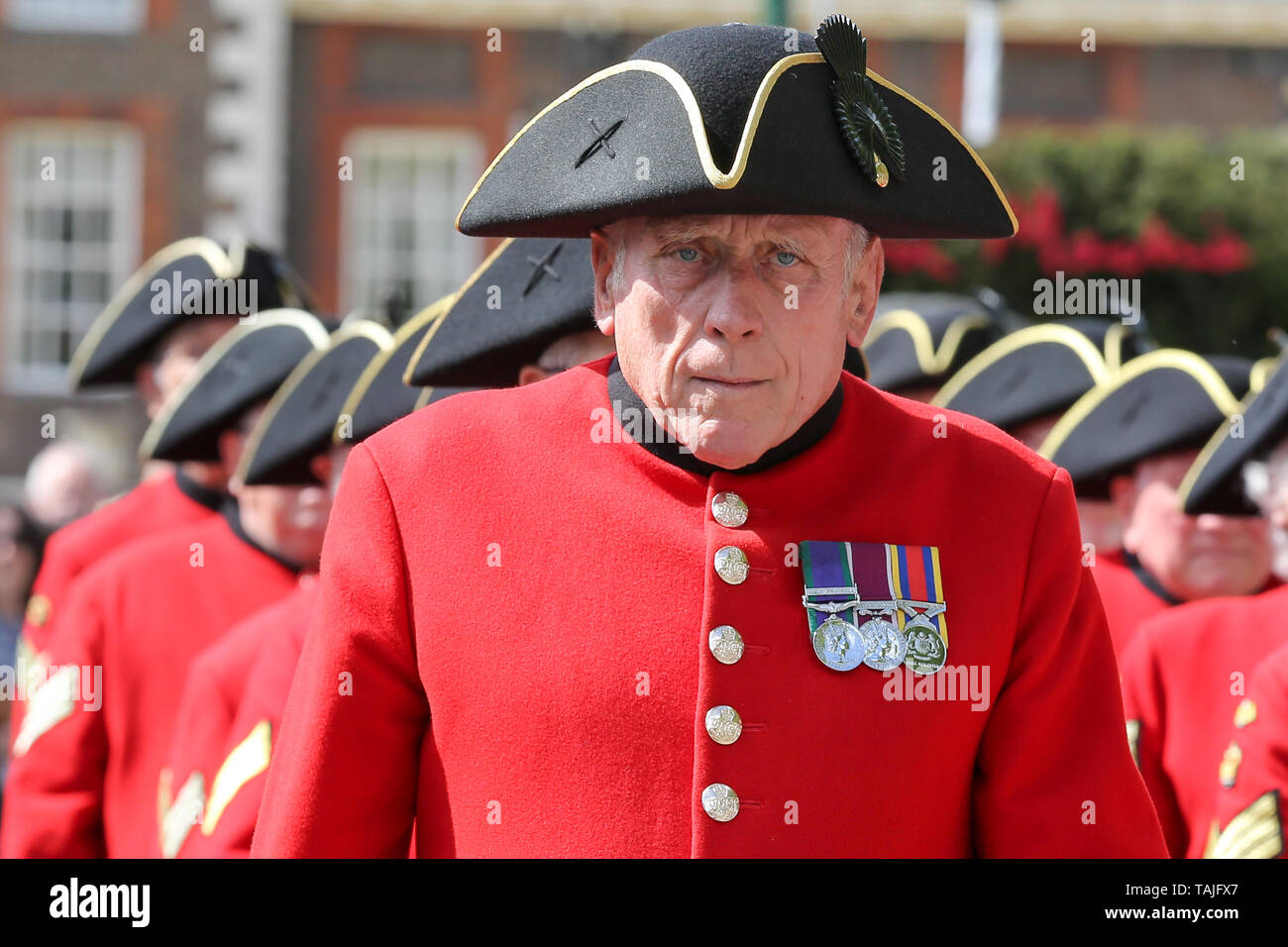 London, UK. 25th May 2019. A Scottish bagpiper leads a Chelsea Pensioners march at the RHS Chelsea Flower Show on the final day of the show. The Royal Horticultural Society Chelsea Flower Show is an annual garden show held in the grounds of the Royal Hospital Chelsea in West London since 1913.  Credit: Dinendra Haria/Alamy Live News Stock Photo