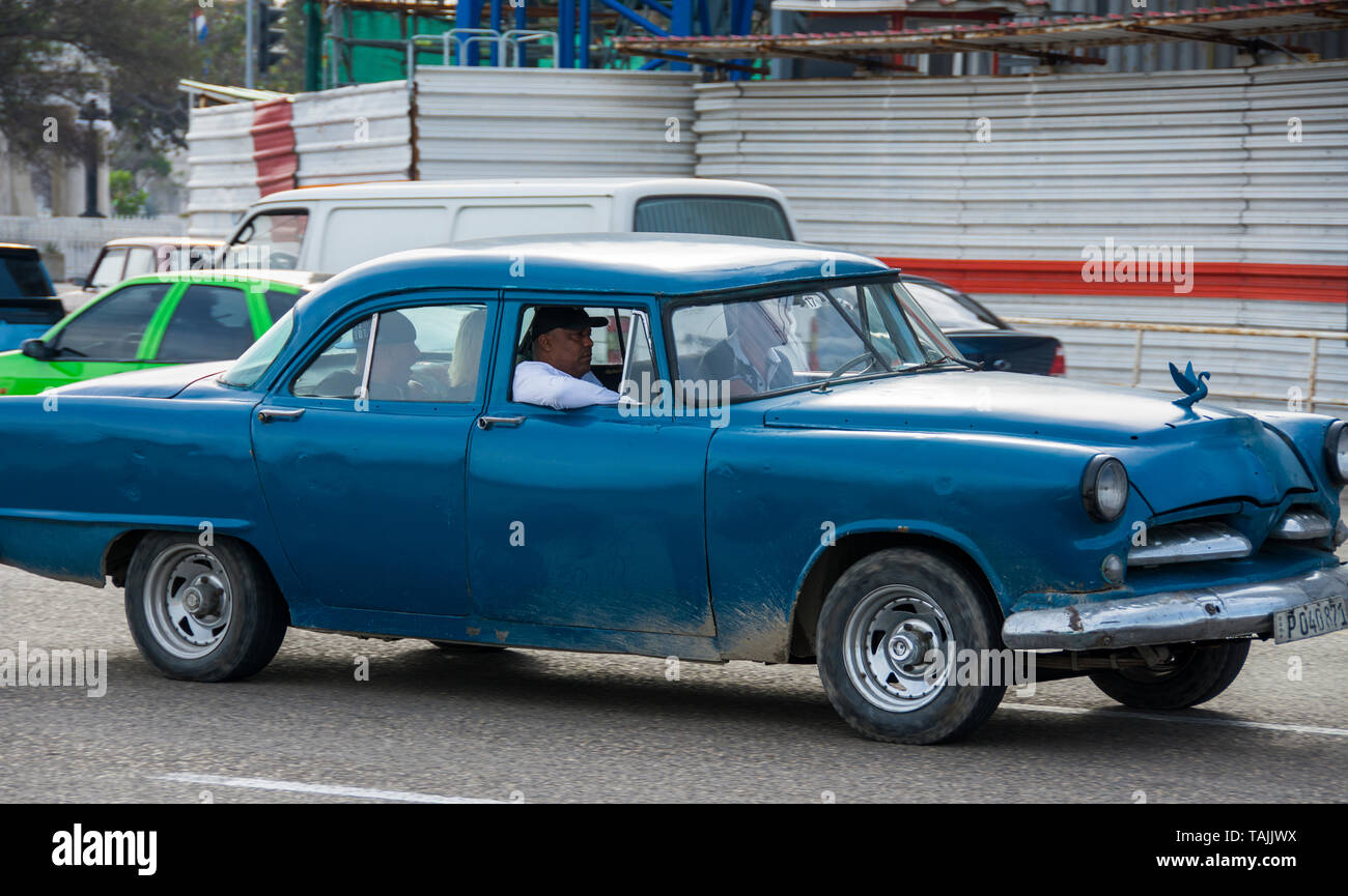 Havana, Cuba - A taxi on the Malecón road facing Havana Bay. Classic American cars from the 1950s, imported before the U.S. embargo, are commonly used Stock Photo