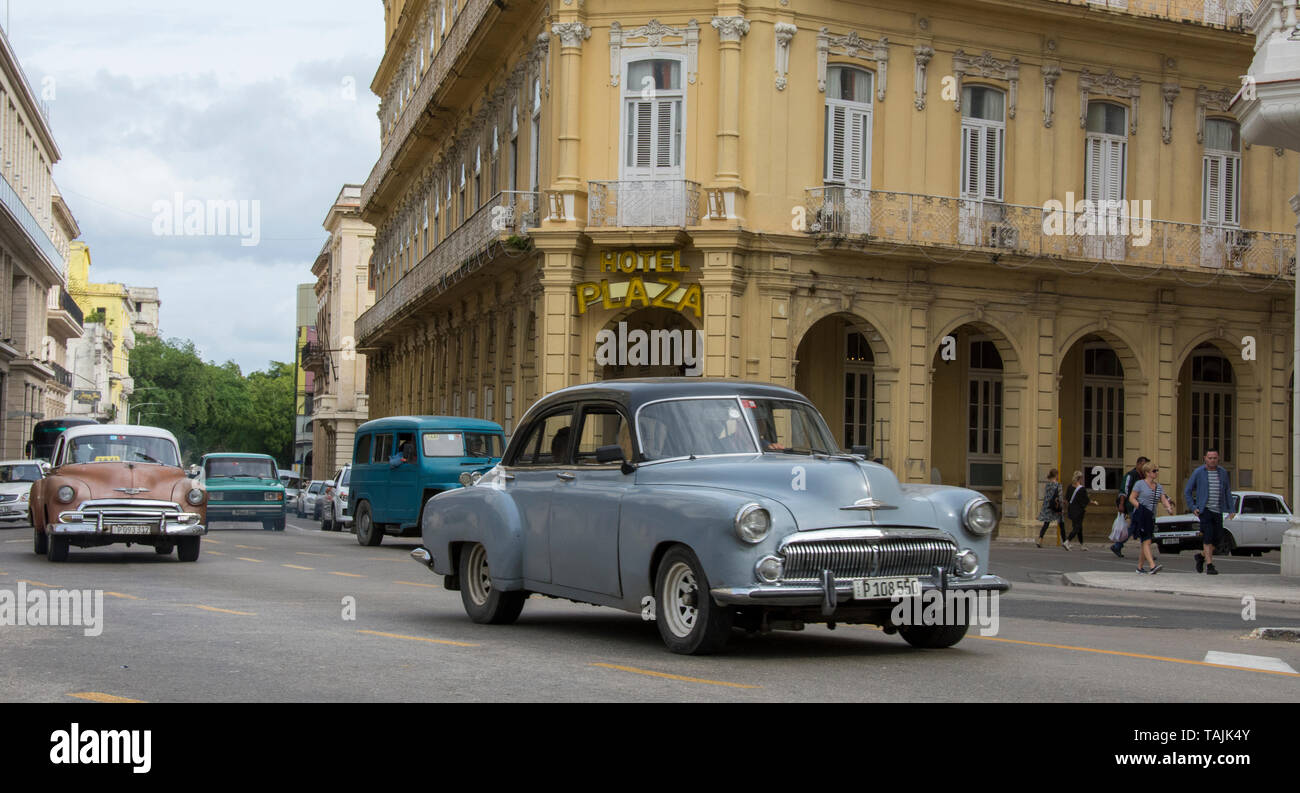 Havana, Cuba - A taxi passes in front of Hotel Plaza near Parque Central. Classic American cars from the 1950s, imported before the U.S. embargo, are  Stock Photo