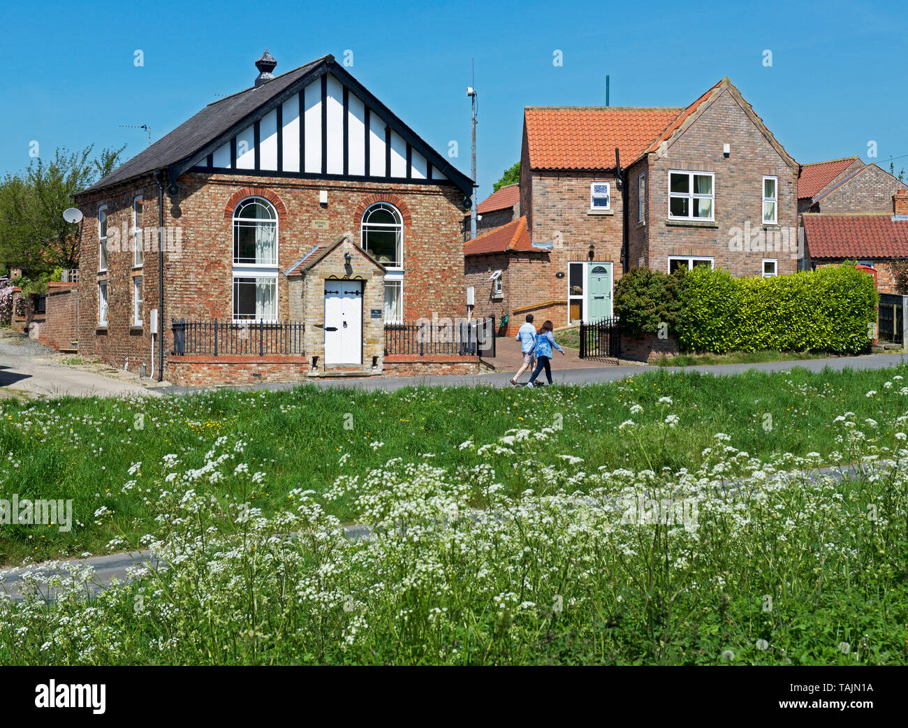 Young man and women walking in the village of Burton, East