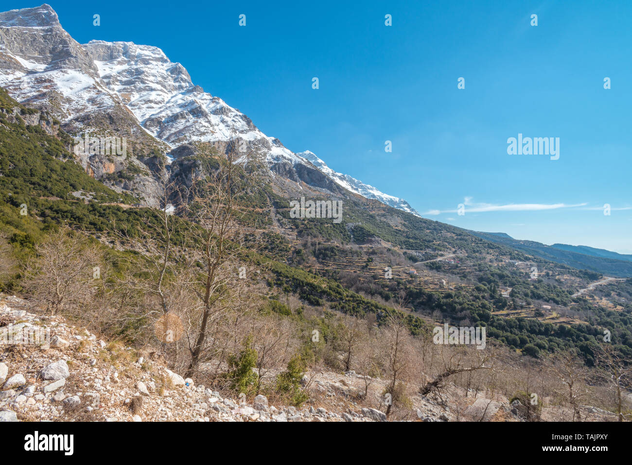High mountains in the Greek Alps, Kataraktis area of Greece. Snowcapped mountain range in blue, cloudless sky. Stock Photo