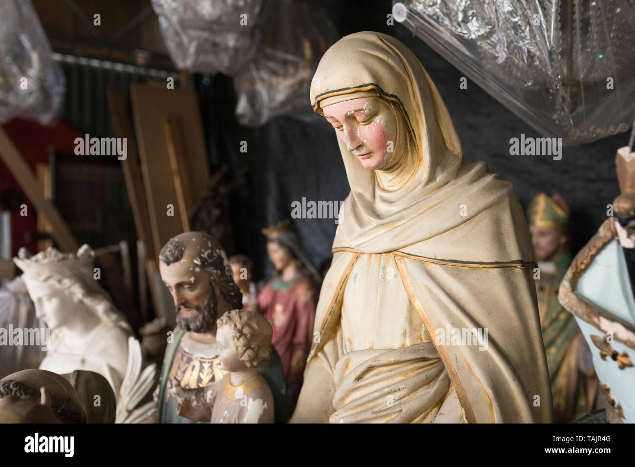 Discarded Roman Catholic Christian statuettes stored in a shed Stock Photo