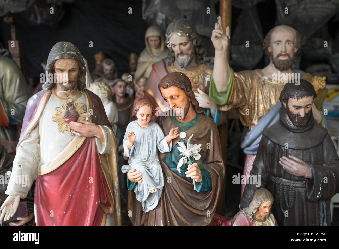 Discarded Roman Catholic Christian statuettes stored in a shed Stock Photo