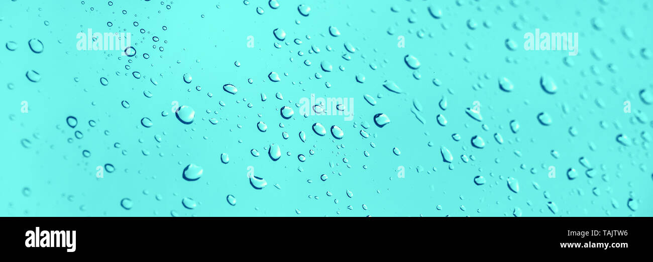 Water drops on glass panoramic blue background Stock Photo