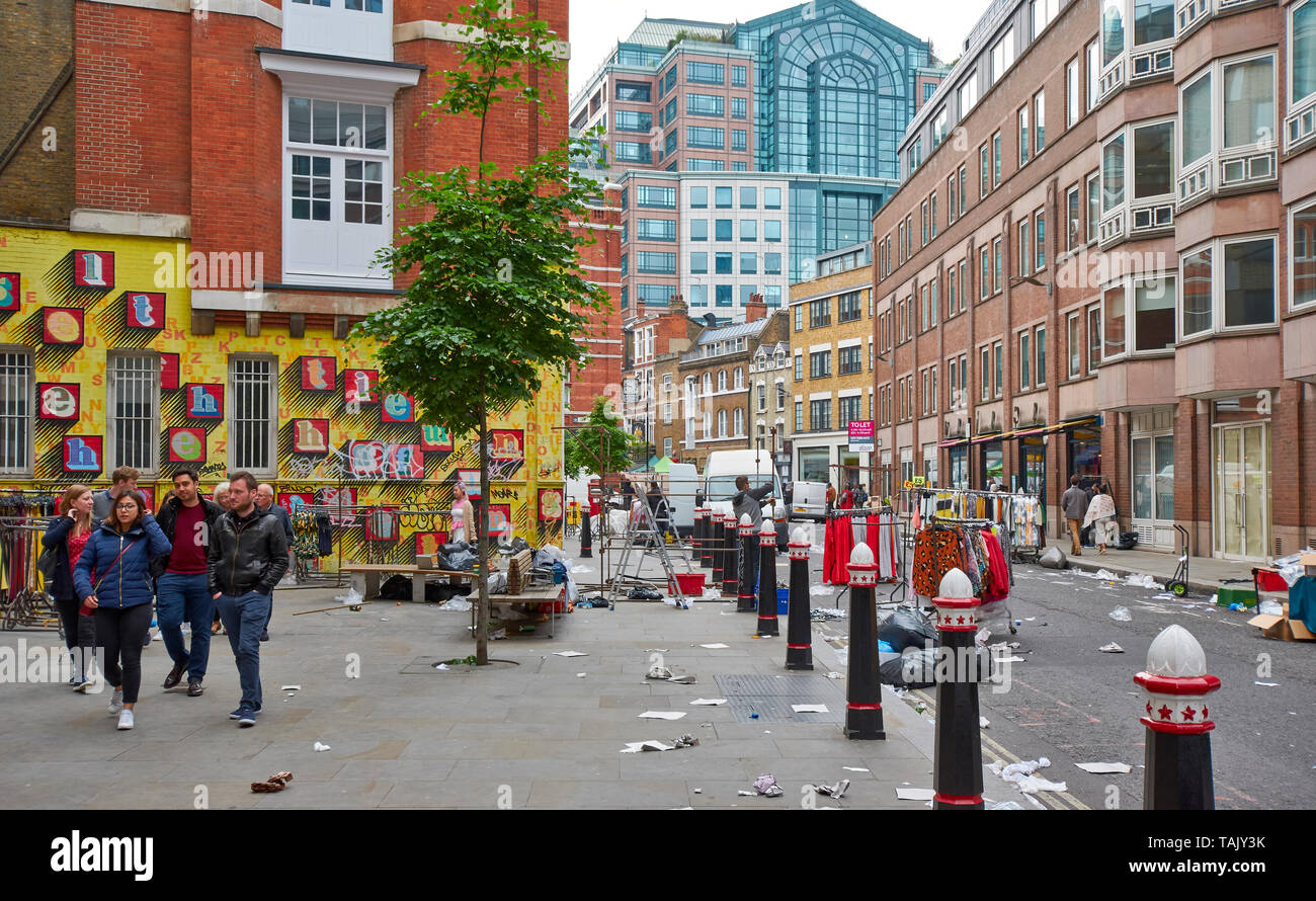 LONDON SPITALFIELDS BRICK LANE AREA STREET AT THE END OF A MARKET DAY WITH ART ON A LARGE BRICK WALL Stock Photo