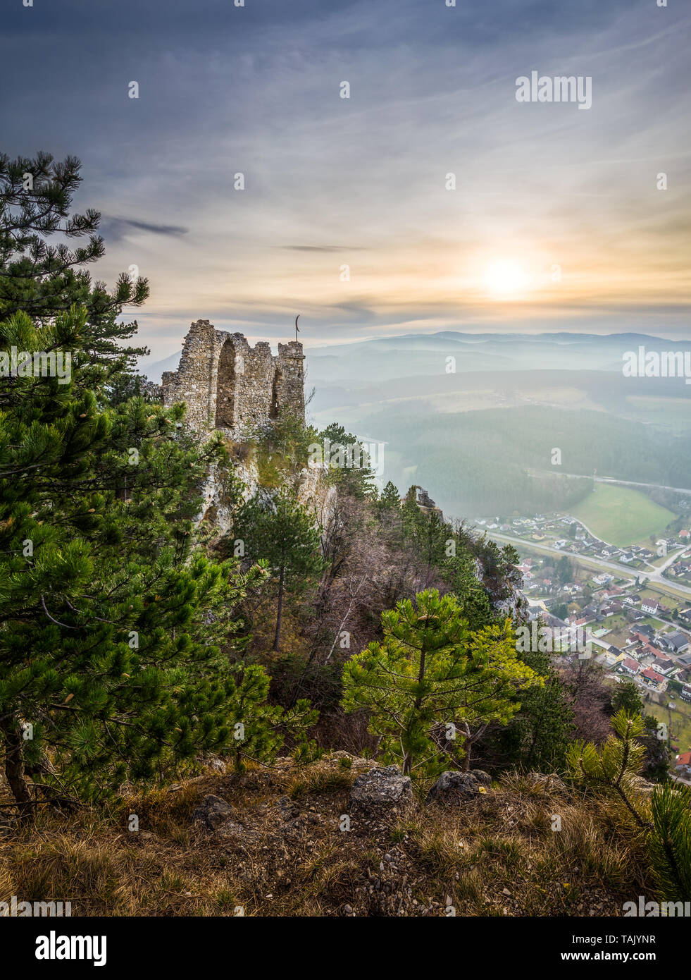 Ruins of a Castle on a Rockface in Gleissenfeld, Austria with Mountains and Village in Background. Located in Nature Park Seebenstein-Turkensturz. Stock Photo