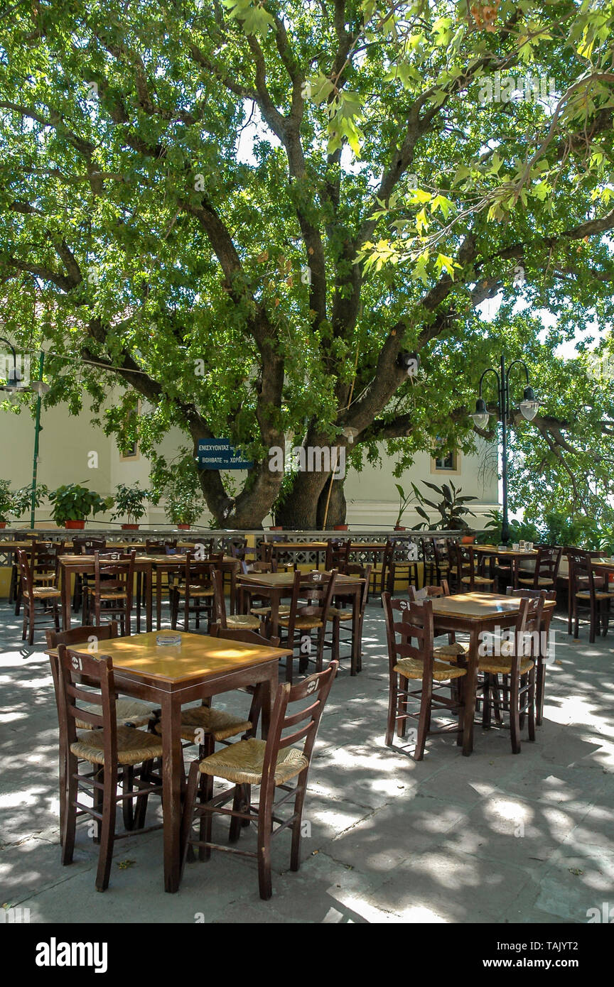 The traditional square of Mesotopos village, in Lesvos (or Lesbos) island, Greece. Chairs of the local kafeneio (traditional greek coffee store) and s Stock Photo