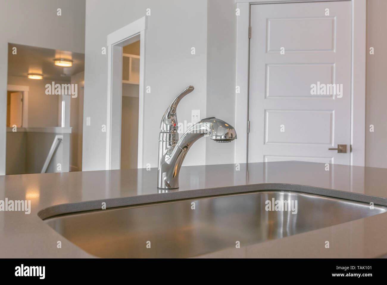 Close Up Of The Shiny Sink And Faucet Inside The Kitchen Of A New