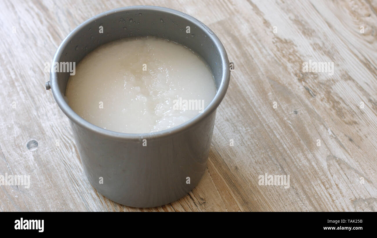 Wallpaper paste in bucket on the floor. Mixing wallpaper glue in bucket.  Apartment renovation concept Stock Photo - Alamy