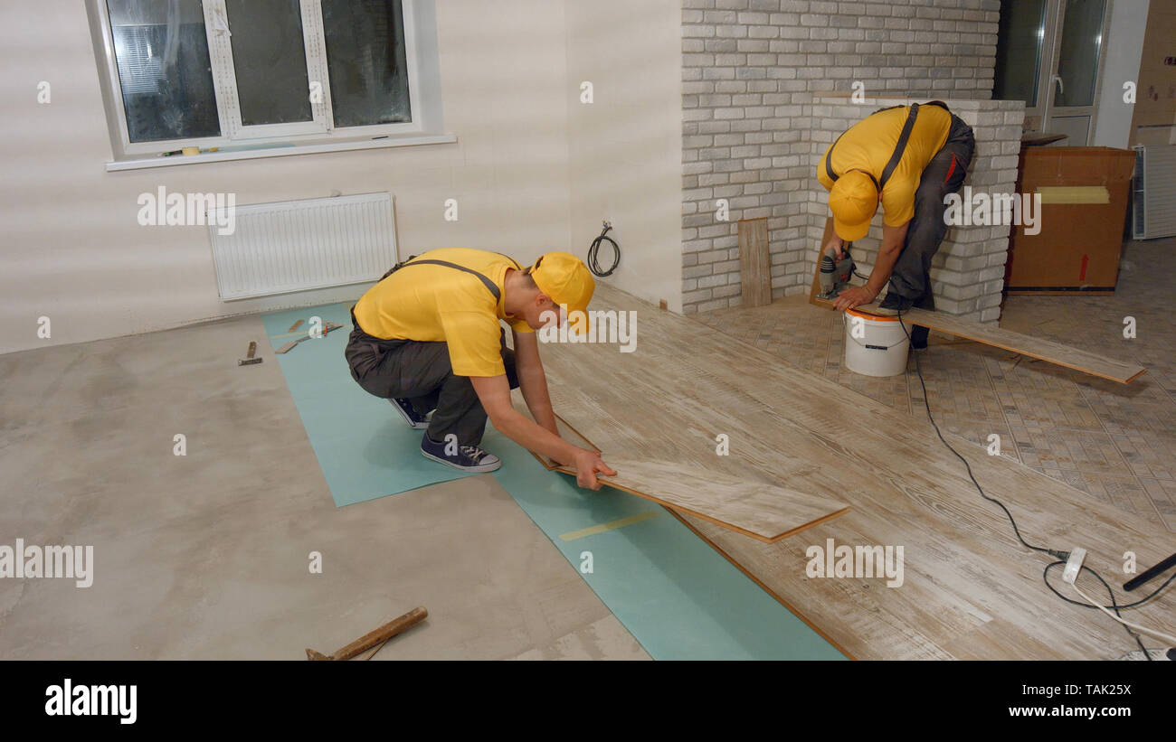 Male Worker Installing New Wooden Laminate Flooring Two