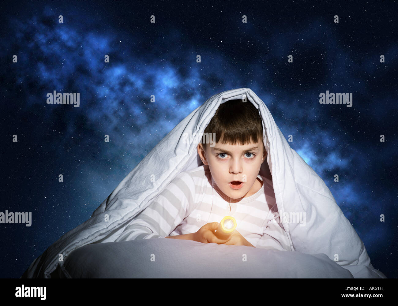 Surprised child hiding under blanket Stock Photo Alamy