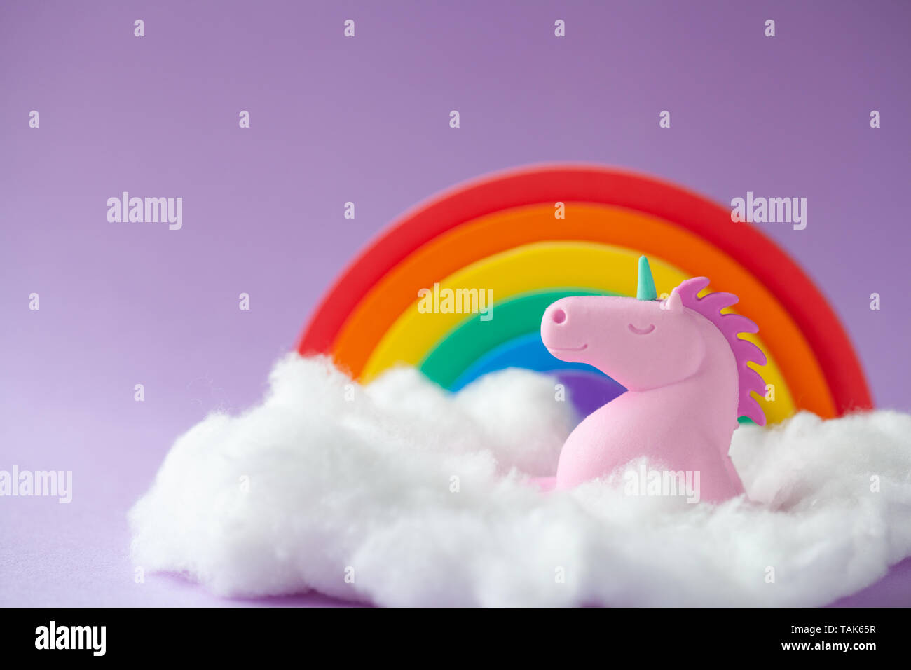 Happy Unicorn Sitting on a cloud with a rainbow Stock Photo - Alamy