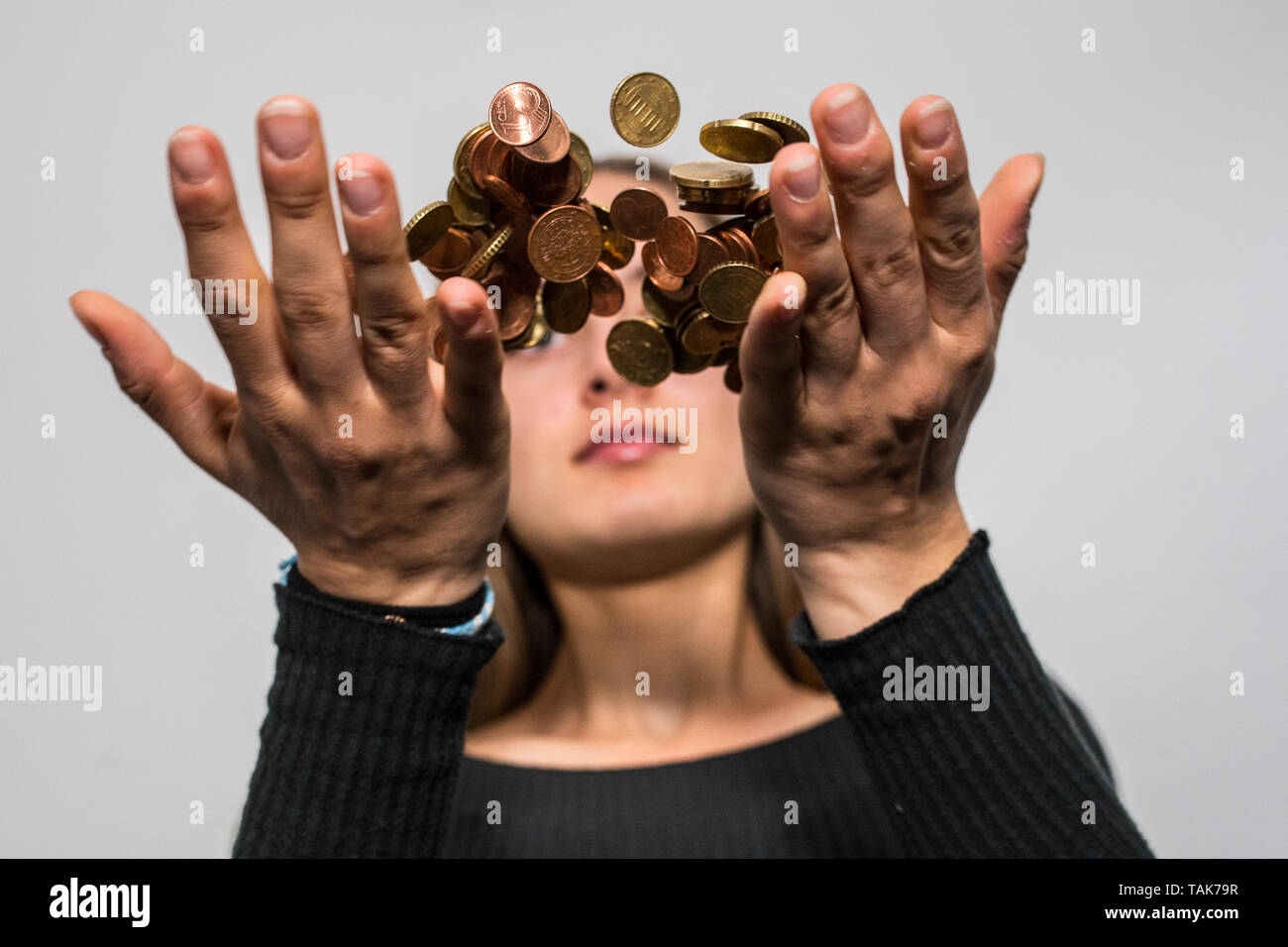 Teenage girl throwing money coins in the air. Stock Photo