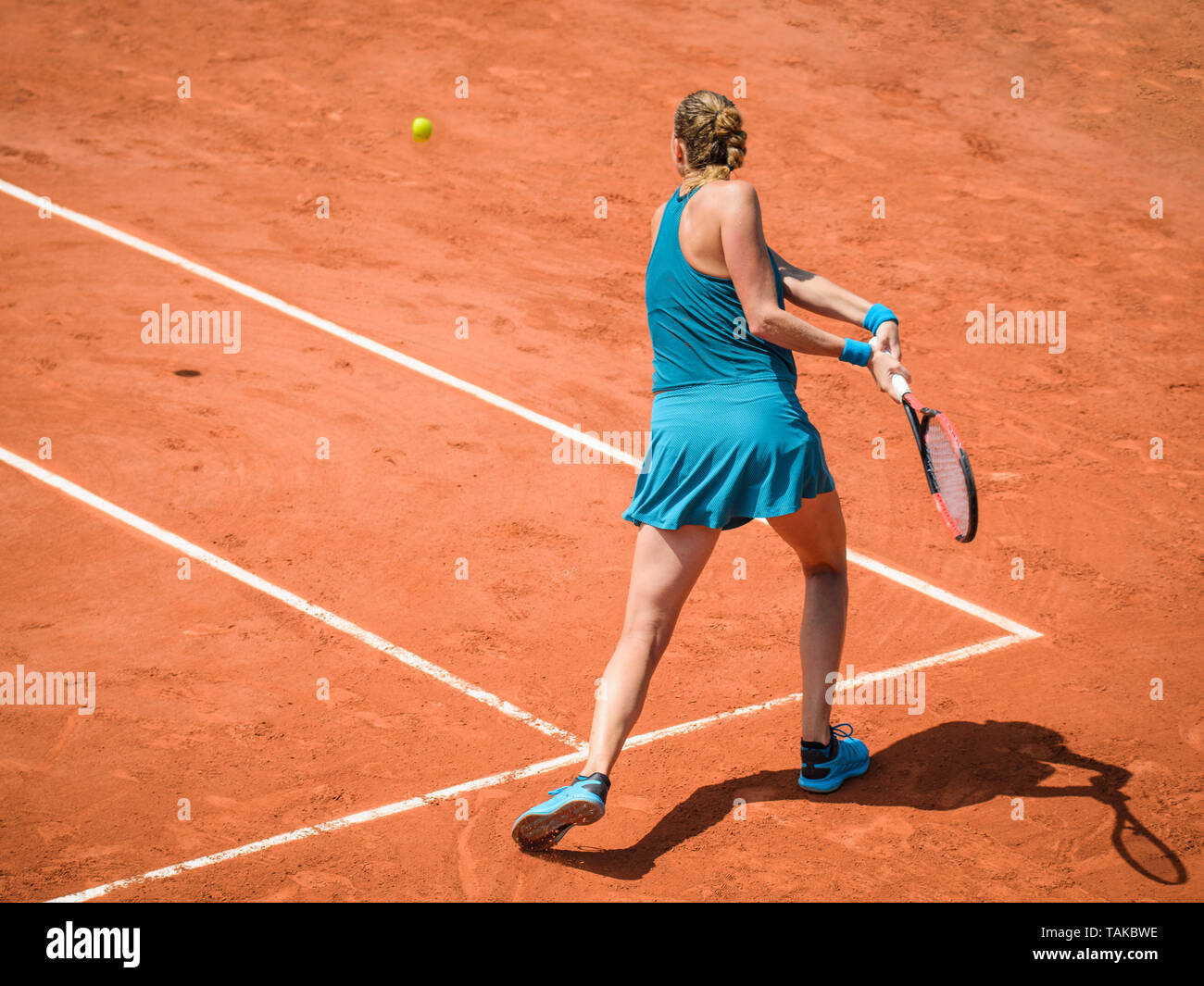 Back view  of a woman playing backhand in tennis outdoor competition game, running, professional Stock Photo