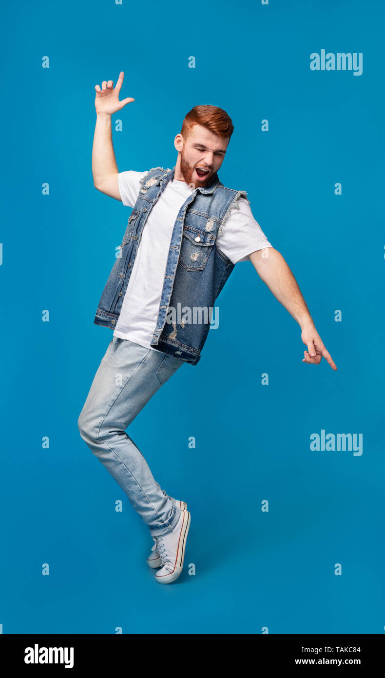 Young cheerful man dancing on tiptoes on background Stock Photo