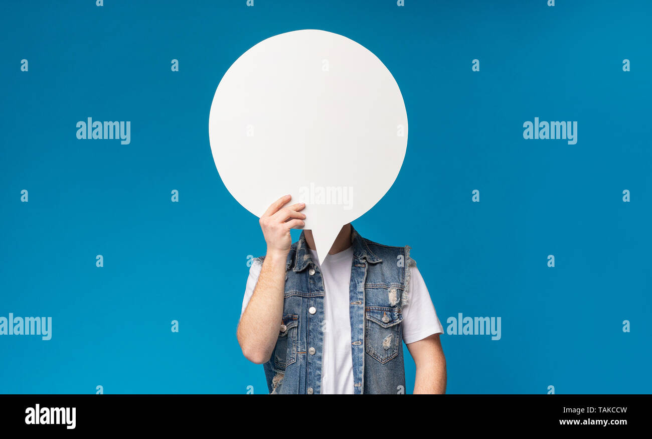 Unrecognizable man hiding his face behind blank speech bubble Stock Photo