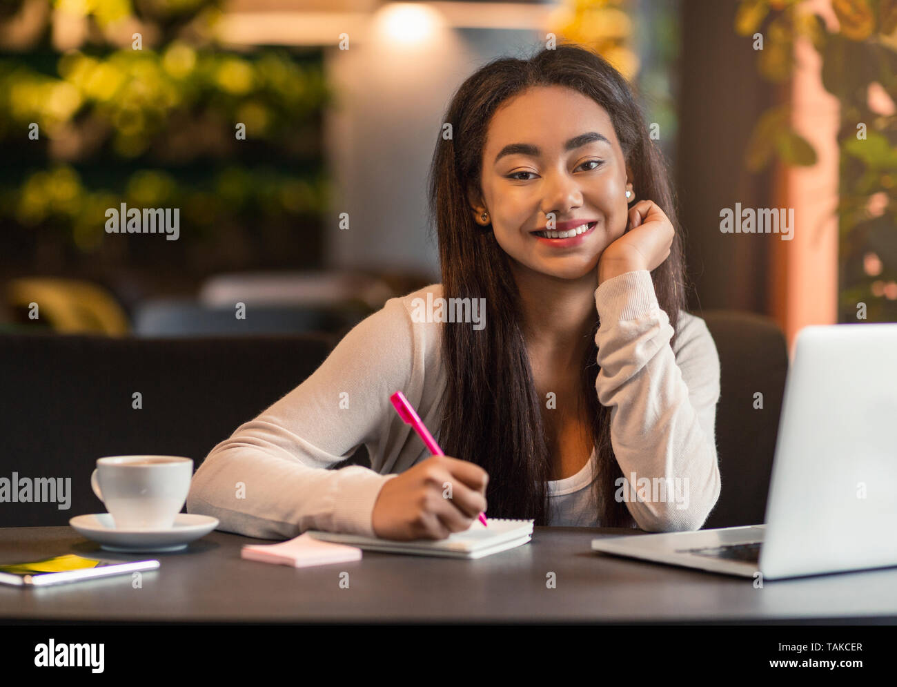 Young african student preparing her exams at local cafeteria Stock Photo