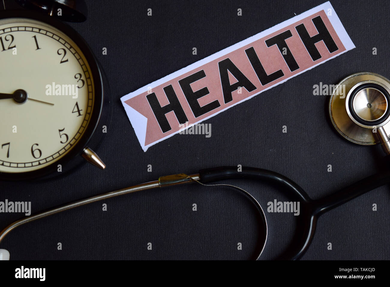 Health on the paper with Healthcare Concept Inspiration. alarm clock, Black stethoscope. Stock Photo