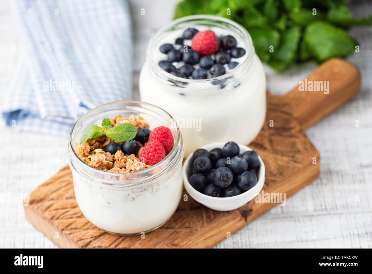 Greek yogurt topped with granola, blueberries, raspberries in a jar Stock Photo