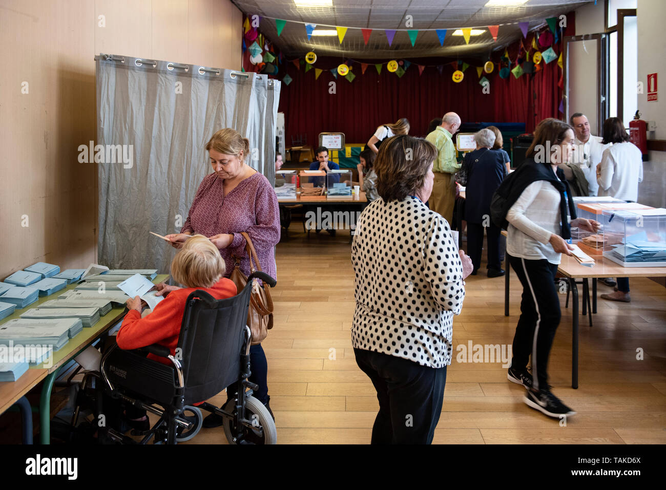 People are seen filling out their ballots at a polling station during the Spanish local, regional and European parliamentary elections in Madrid. Stock Photo