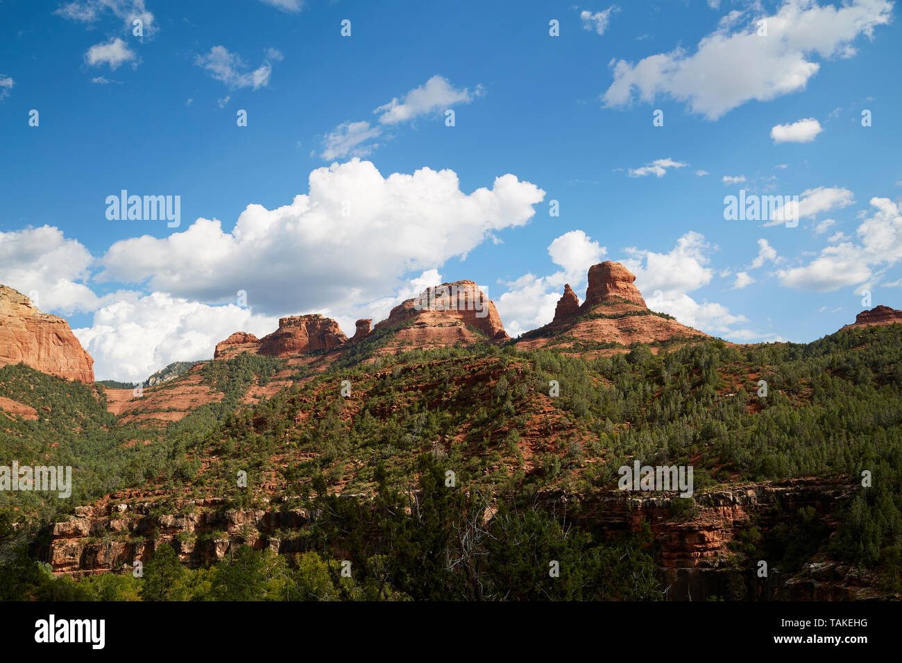 Red Rock canyons with rock formations against blue sky and fluffy white clouds. Stock Photo