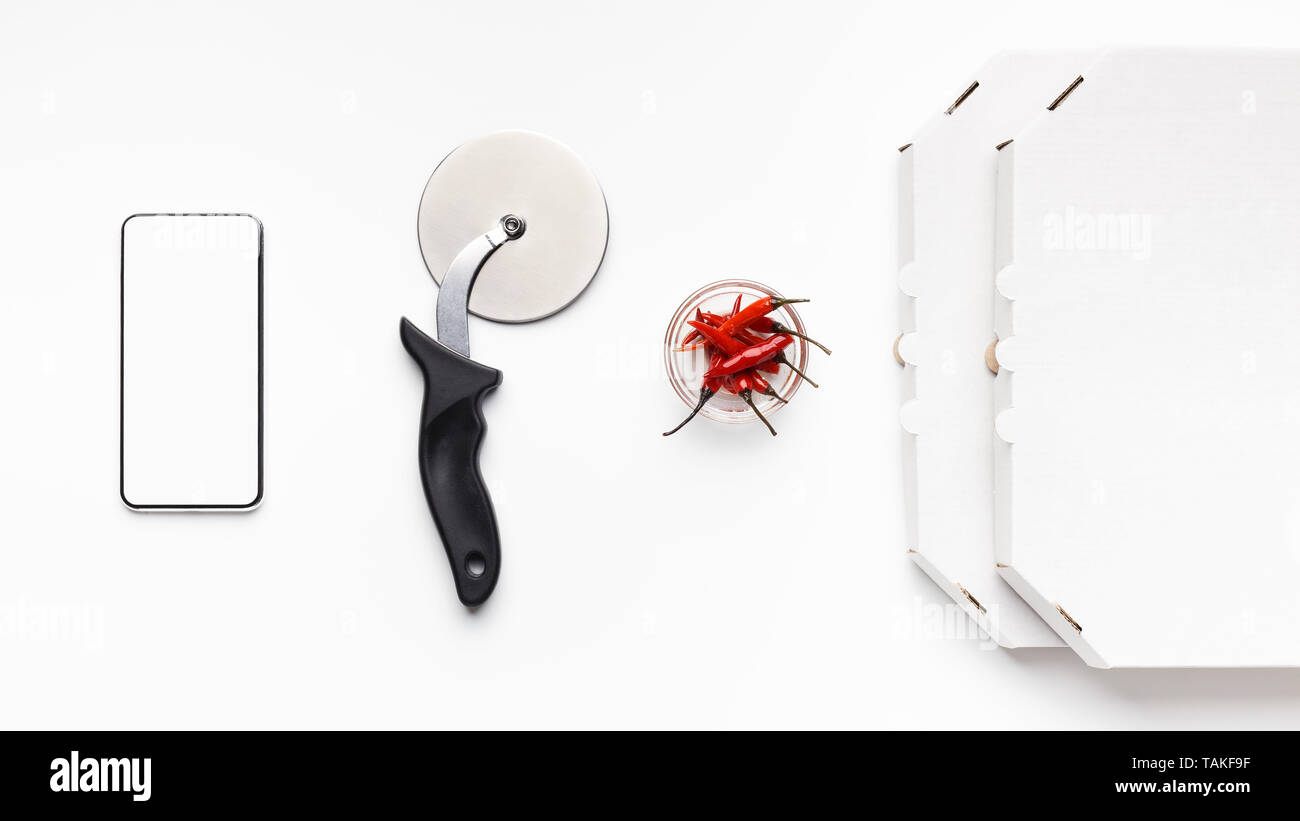 Phone, Cutter, Bowl With Chilli Peppers And Delivery Boxes Stock Photo