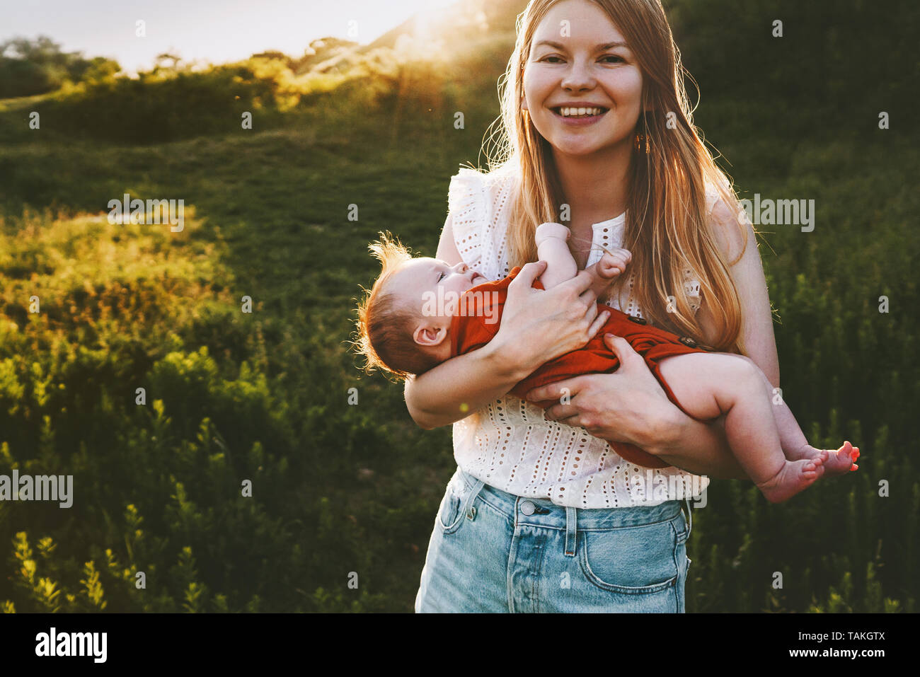 Happy mother walking with infant baby outdoor family lifestyle young mom and child traveling together maternity Mothers day Stock Photo