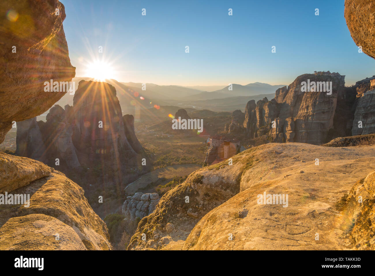 Golden hour sunset from sunset rock in Meteora, Greece, overlooking Roussanou and Grand Meteora monasteries in the valley. Stock Photo