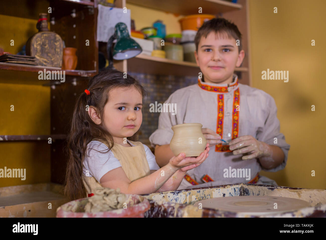 Pottery class and children trying to make ceramic wares in