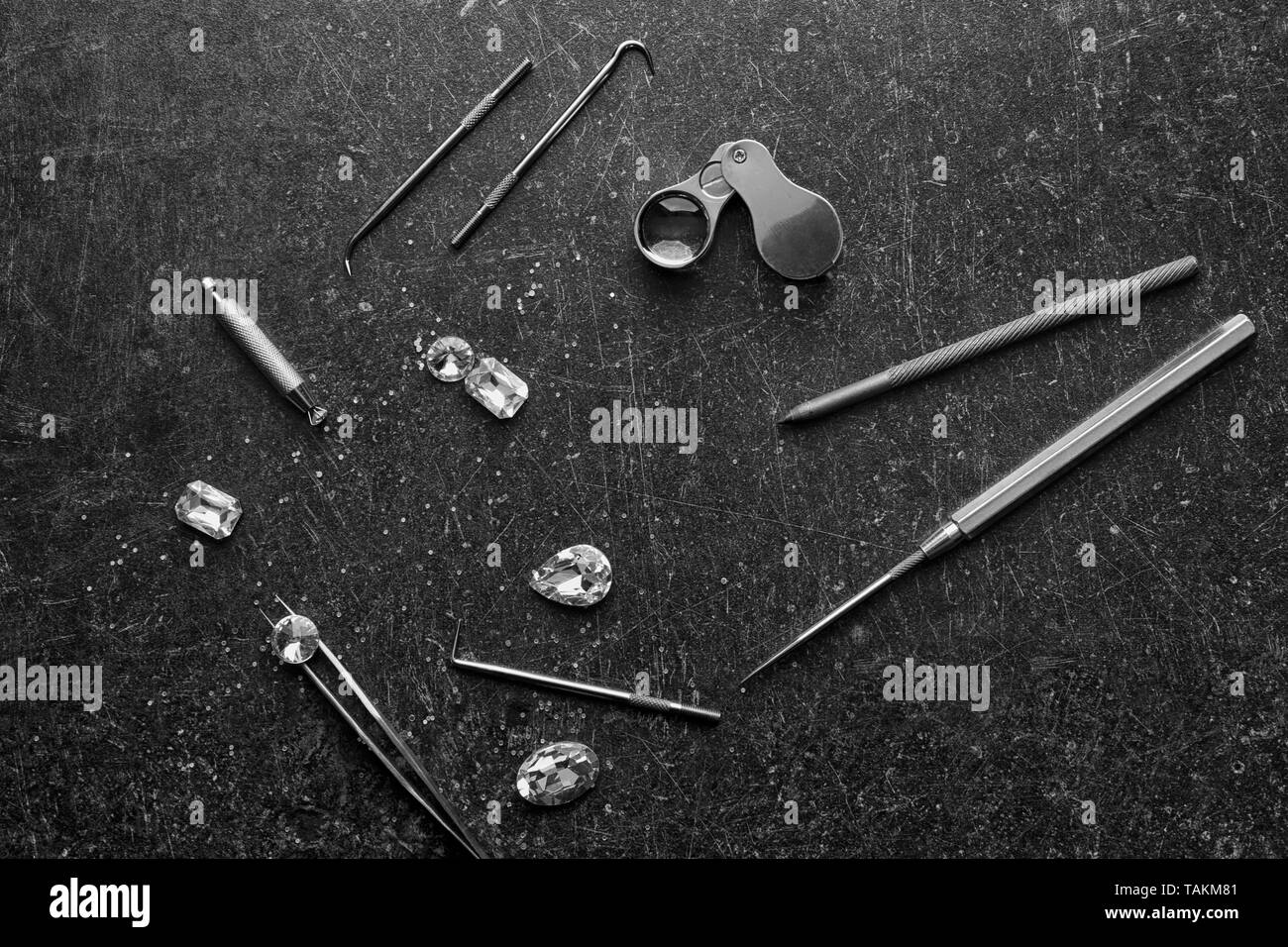 Precious stones and jeweler's tools on grey background Stock Photo Alamy
