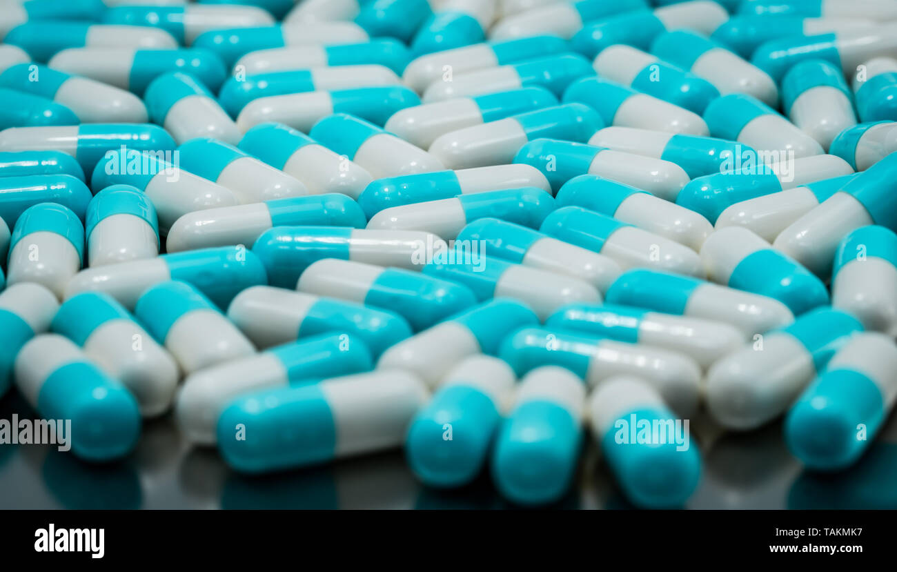 Selective focus on blue and white antibiotic capsule pills. Pharmaceutical industry. Antibiotic drug resistance concept. Pharmaceutics concept. Pastel Stock Photo