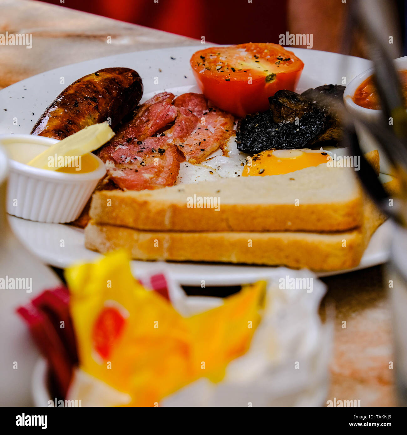 Traditional Cooked English Breakfast Sausage Bacon and Eggs With Toast. Stock Photo