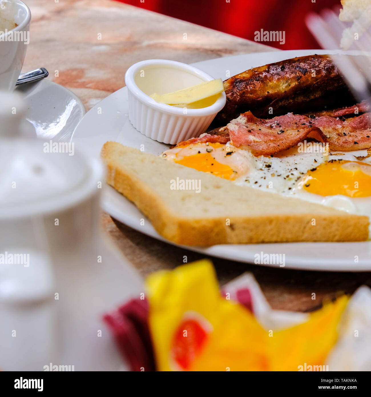 Traditional Cooked English Breakfast Sausage Bacon and Eggs With Toast. Stock Photo