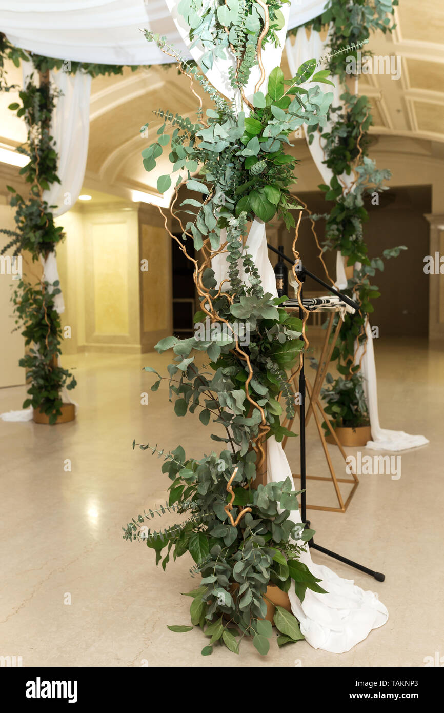 Wedding chuppah decorated with fresh flowers indoor banquet hall of