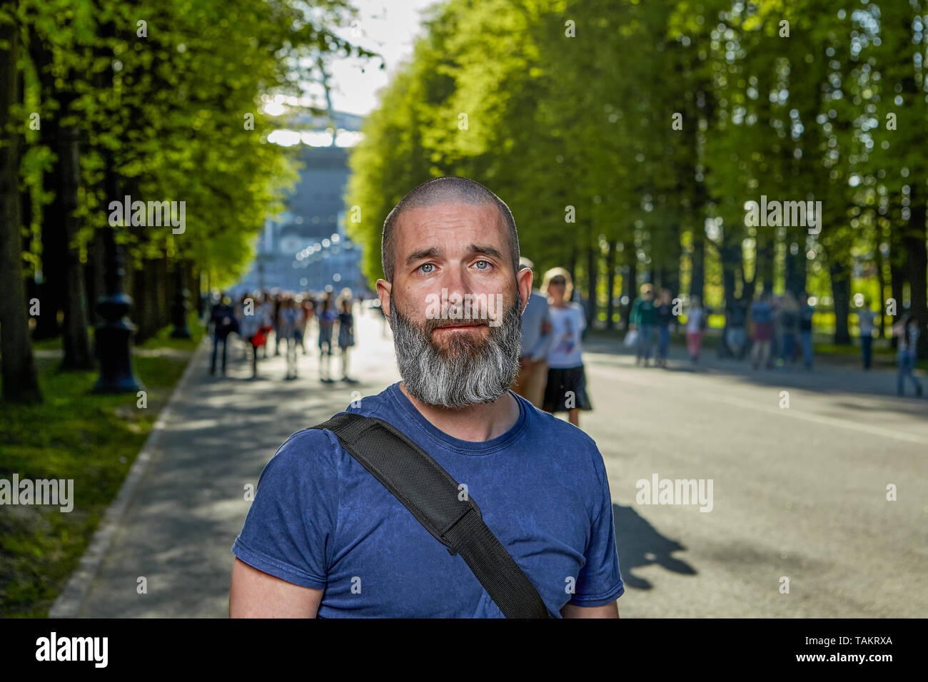 A caucasian man about 40-44 years old with short hair and beard is walking in the park, close-up. Stock Photo