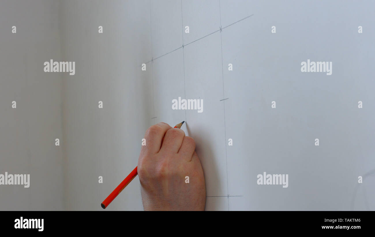 Hand make wall marking with pencil. Construction worker using pencil to