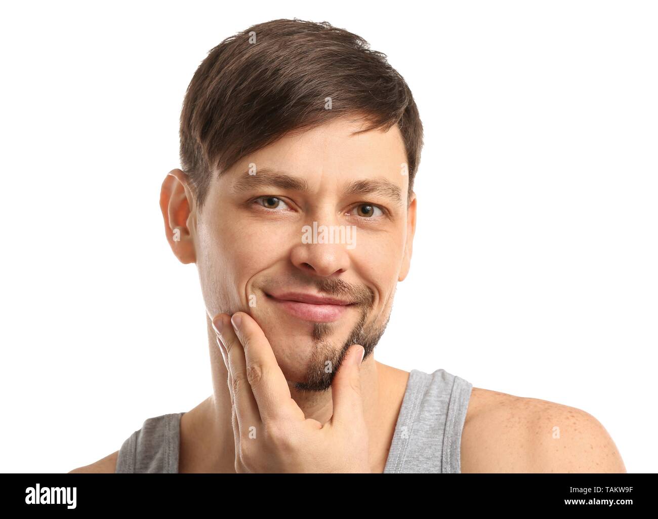 Handsome man having half of his face shaved against white background Stock Photo